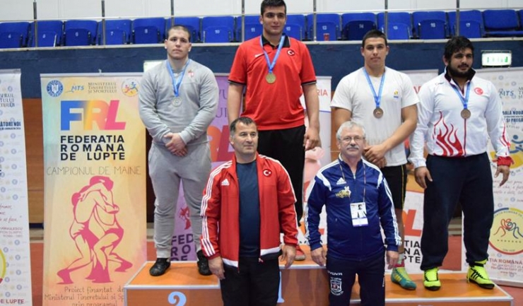 Sebastian Raicea (al doilea de la dreapta la stânga) pe podiumul categoriei 120 kg; în fața lui stă antrenorul Ioan Giuglea