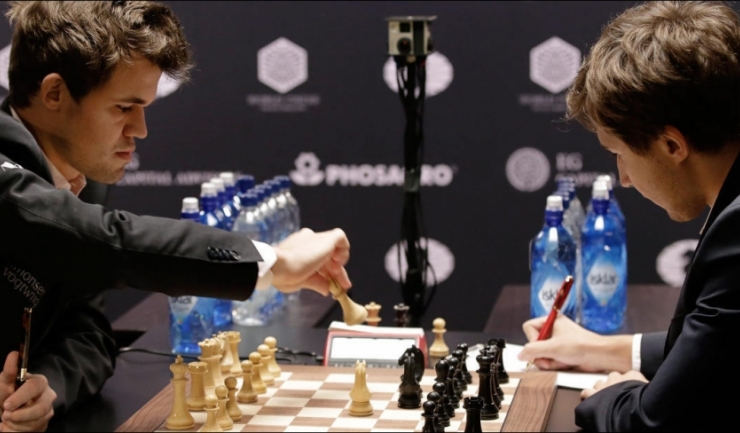 Magnus Carlsen (stânga) a cucerit pentru a treia oară consecutiv titlul de campion mondial la șah