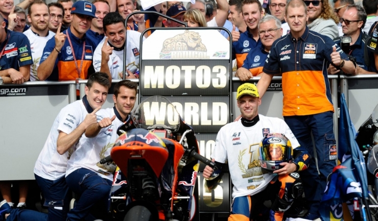 Sud-africanul Brad Binder (dreapta jos, alături de staff-ul echipei sale, KTM) este campionul mondial en titre la clasa Moto3