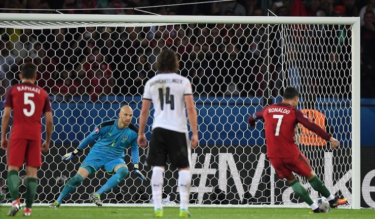 Cristiano Ronaldo îl fentează pe portarul austriac Almer, însă mingea va lovi bara