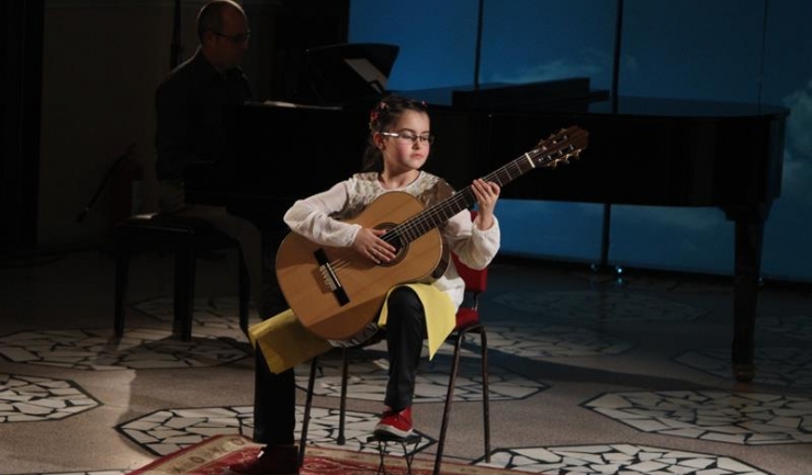 Micuța Eva Maria Stanciu studiază chitara clasică cu profesorul și basul constănţean Constantin Acsinte