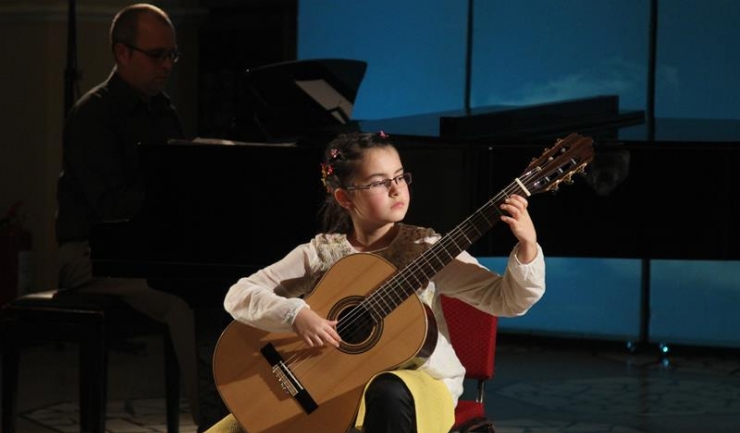 Micuța Eva Maria Stanciu studiază chitara clasică cu profesorul și basul constănţean Constantin Acsinte